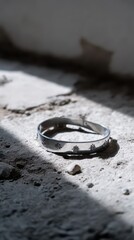 Silver Peace Symbol Bangle Resting on Textured Surface in Serene Setting