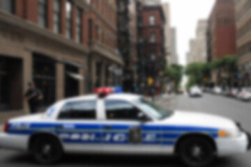 Blurry photo of a police car patrolling the busy city center.