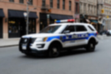 Blurry photo of a police car patrolling the busy city center.