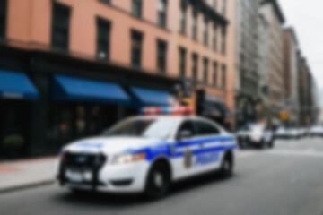 Blurry photo of a police car patrolling the busy city center.