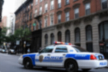 Blurry photo of a police car patrolling the busy city center.