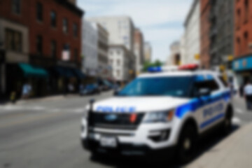 Blurry photo of a police car patrolling the busy city center.