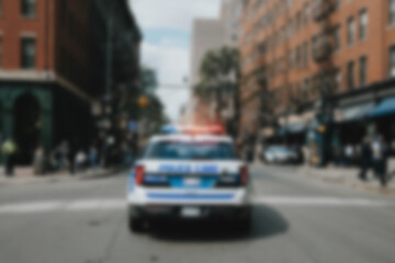 Blurry photo of a police car patrolling the busy city center.