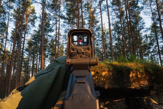 First-Person View (POV): A soldier aiming an assault rifle with a red dot sight at a drone.