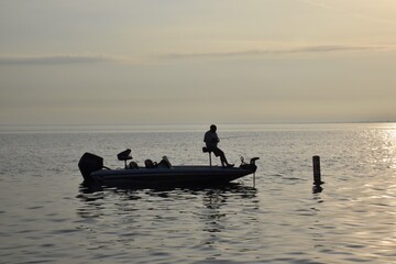 Angler fishing at sunrise in a boat