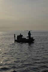 Angler fishing at sunrise in a boat