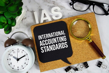 IAS - International Accounting Standards acronym with calculator, alarm clock and magnifying glass,...