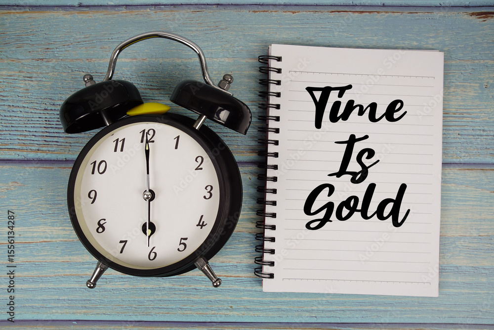Poster time is gold text written on notepad with alarm clock on wooden background