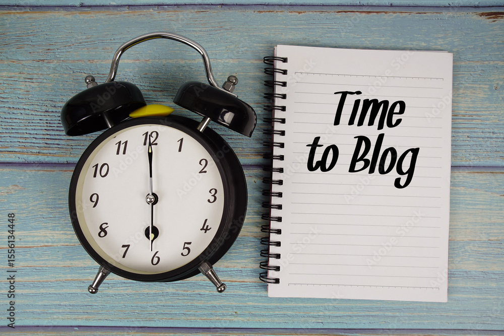 Poster time to blog text written on notepad with alarm clock on wooden background