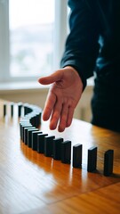 A hand stopping dominoes
