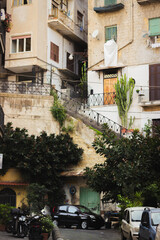 Fototapeta premium A charming street in Naples, Italy showing Mediterranean architecture, potted plants, laundry, and a sense of lived-in authenticity and local life. 