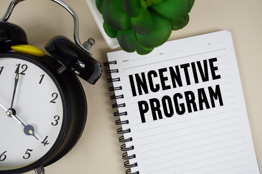 Incentive program text written on notepad with alarm clock