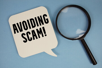 Avoiding Scam! text with magnifying glass on blue background