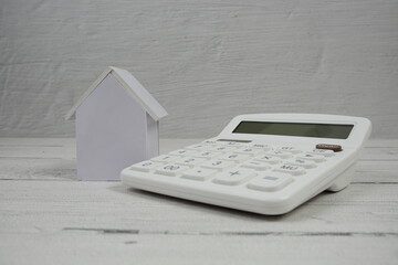 House Model and Caculator on wooden background