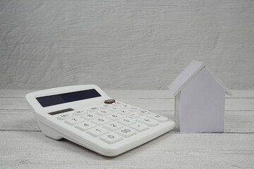 House Model and Caculator on wooden background