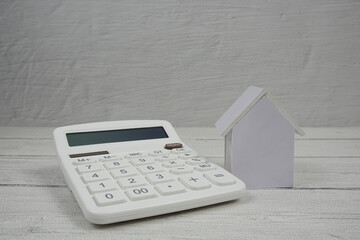 House Model and Caculator on wooden background