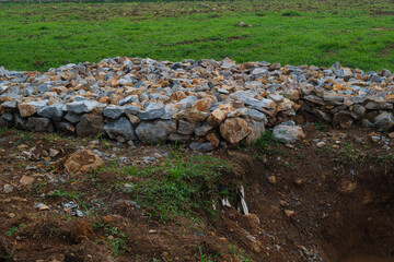 Pile of Rocks on Grass Next to a Dirt Excavation Site