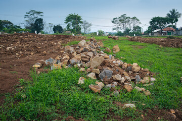 Pile of Rocks on Green Field with Overcast Sky in Rural Area