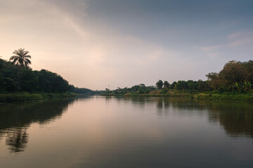 Calm River Flowing Through Lush Landscape with Trees and Gentle Reflections