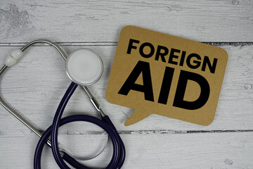 Foreign Aid text with Stethoscope on wooden background