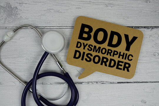 Body Dysmorphic Disorder (BDD) text with Stethoscope on wooden background