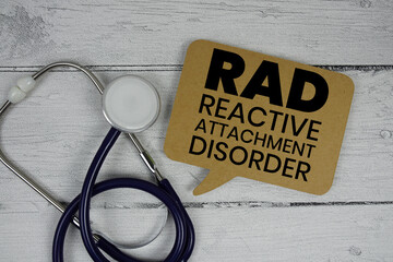 RAD Reactive Attachment Disorder text with Stethoscope on wooden background