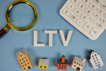 LTV abbreviation of Loan To Value alphabet letters with house model, magnifying glass and...