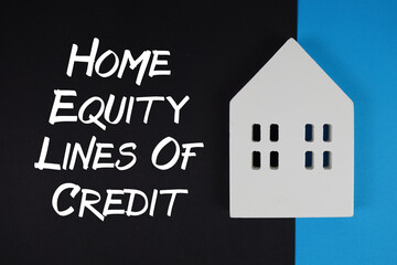 Heloc Home Equity Lines Of Credit text with house models on black background