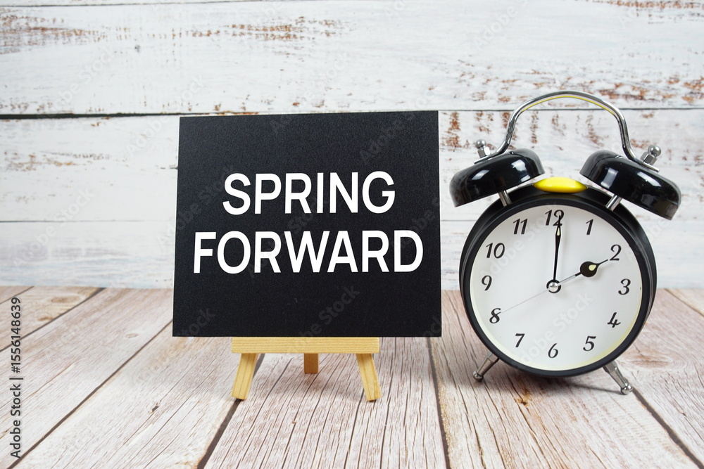 Aufkleber spring forward text with easel and alarm clock on wooden background