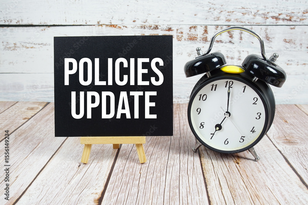 Poster policies update text with easel and alarm clock on wooden background