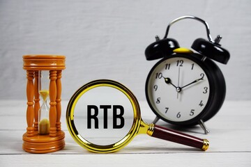 RTB abbreviation of Real Time Bidding text with alarm clock on wooden background