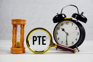 PTE abbreviation of Part time Equivalent text with alarm clock on wooden background
