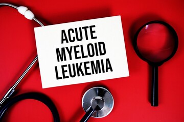 Acute Myeloid Leukemia text written on paper card with stethoscope on red background