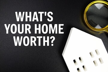 What's Your Home Worth? text message with white house model and magnifying glass top view on black...