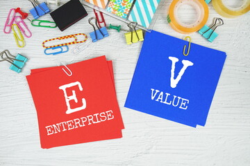 EV - Enterprise Value text on stick note with stationery on concrete background