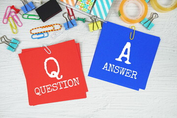 QA - Question And Answer text on stick note with stationery on concrete background