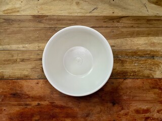 Empty white plastic bowl isolated on brown wooden table, Bowl on wooden chopping board
