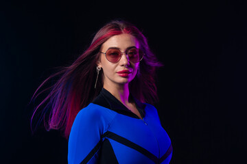 Stylish futuristic woman in blue bodysuit and sunglasses