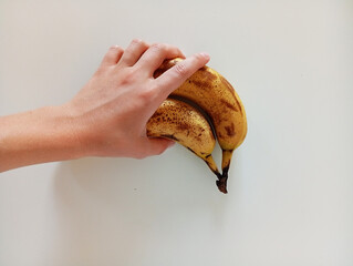 hand holding yellow bananas on white background