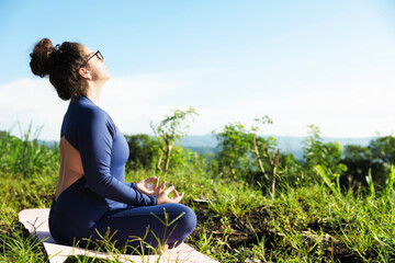 Woman meditating on yoga mat outdoors. Space for text