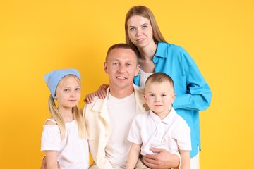 Family portrait of parents and their children on yellow background