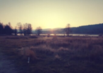Fototapeta premium Blurred tranquil sunrise over countryside landscape