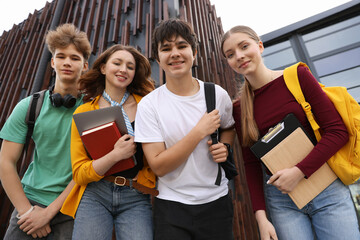 Group of happy teenagers near building outdoors, low angle view