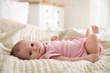 Cute newborn baby lying on bed indoors