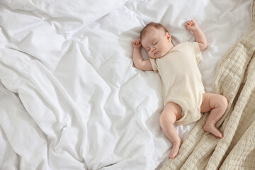 Cute newborn baby sleeping on bed indoors, top view. Space for text
