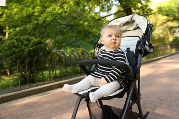 Cute little baby in stroller at park. Space for text