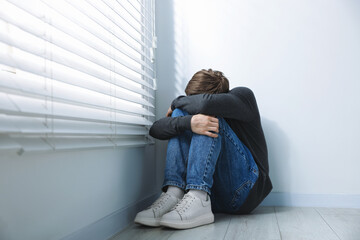 Man suffering from paranoia near window at home