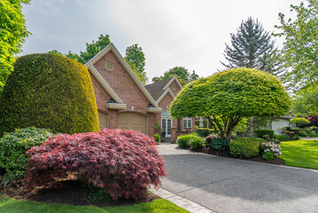 Establishing shot. Two story stucco luxury house with nice spring blossom landscape in Vancouver,...