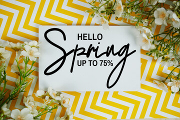 Hello Spring Sale 75% off with artificial flowers decoration on yellow chevron background