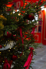 Decorated Christmas tree with Christmas balls, tinsel and warm yellow lights. Festive atmosphere.